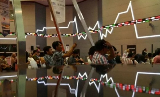 Sejumlah pengunjung duduk berlatar belakang pergerakan Indeks Harga Saham Gabungan